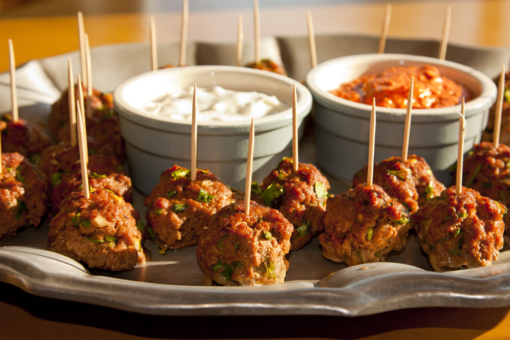 Lamb meatball appetizers or snacks (Keftedes) with Tzatziki and Romesco